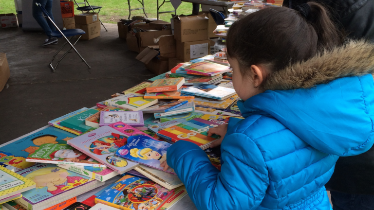A child viewing books on a table