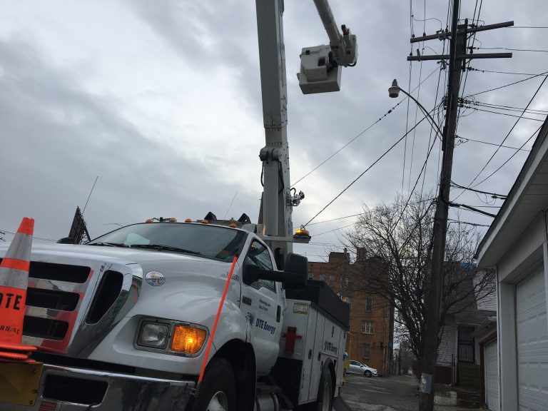 A DTE Energy truck holds up a repair crewman to restore power.
