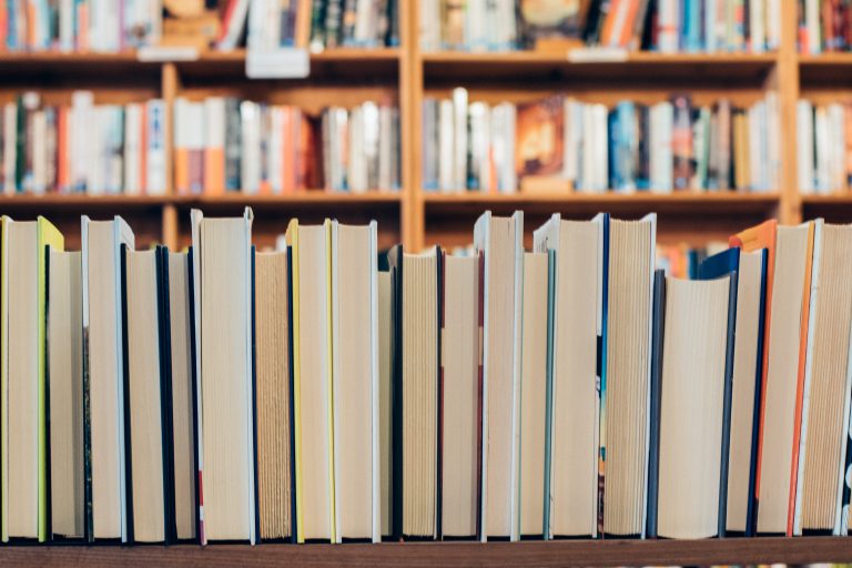 A row of books on a shelf viewed from the page side.