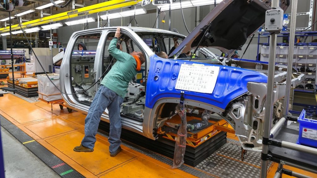 An assembly worker working on a Chevy Silverado at the Flint Assembly Plant.