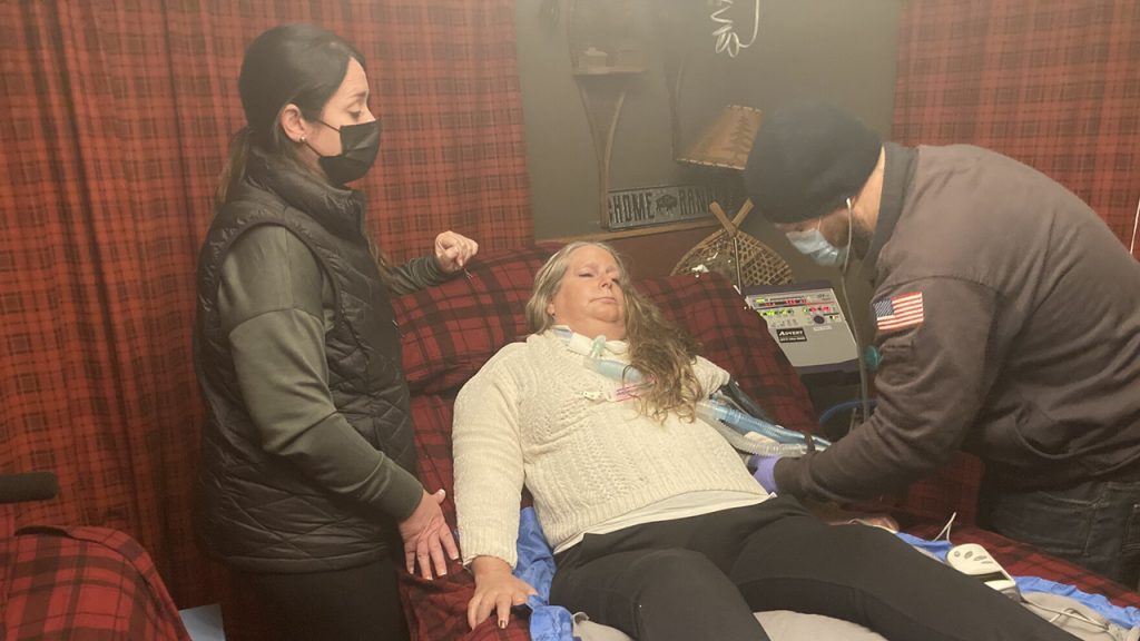 Kelley Miller lies in a stretcher as a nurse watches a first responder takes her vitals