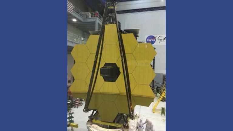 NASA scientists next to the large James Webb Space Telescope.