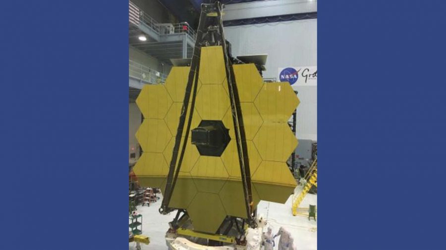 NASA scientists next to the large James Webb Space Telescope.