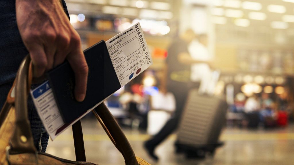 A boarding pass is tucked into a passport