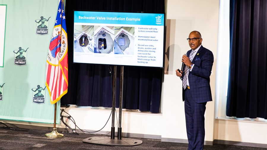 Gary Brown stands next to a presentation against a white wall