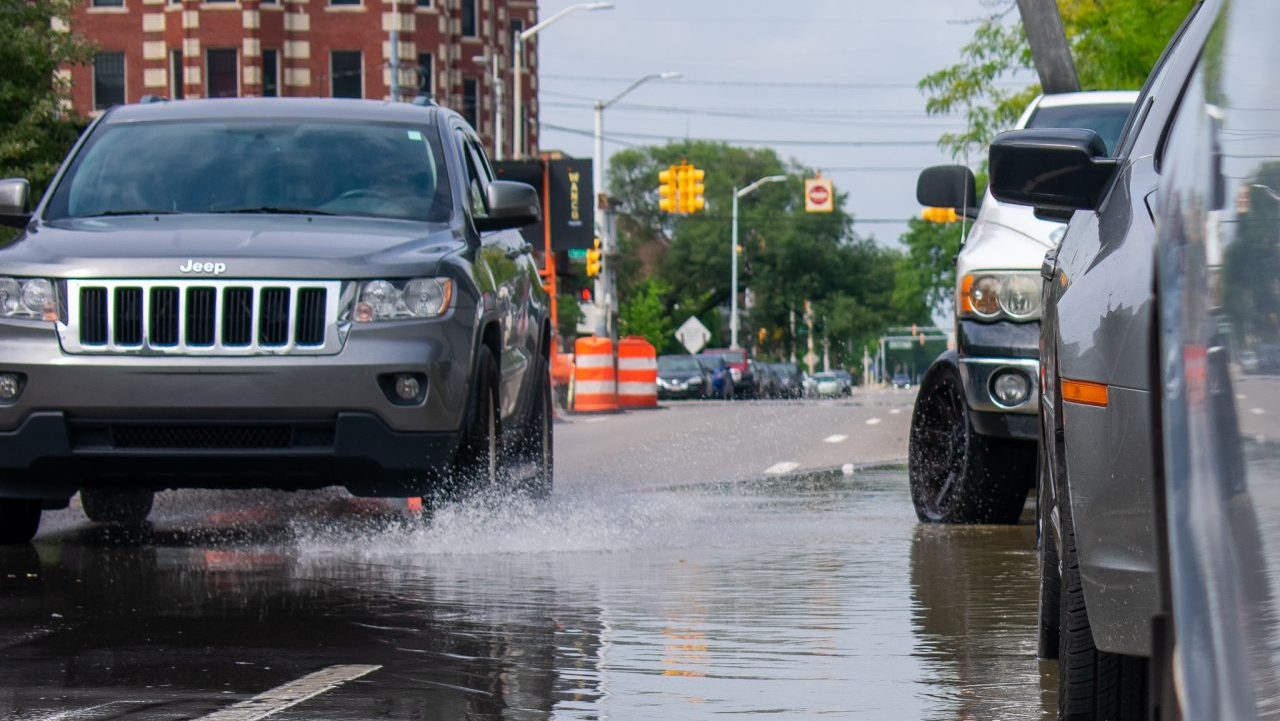 A car drives through a puddle left after a downpour of rain in Detroit.