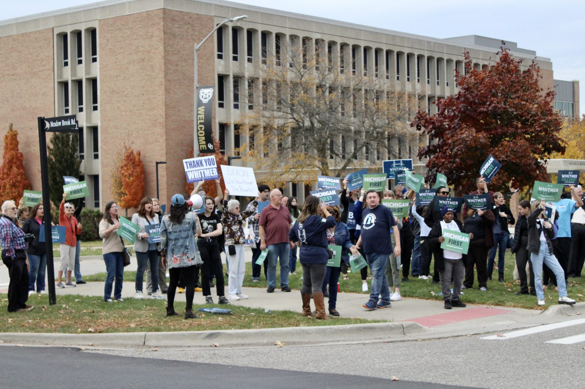 supporters stand with political signs outside gubernatorial debate at Oakland University 10/25/22