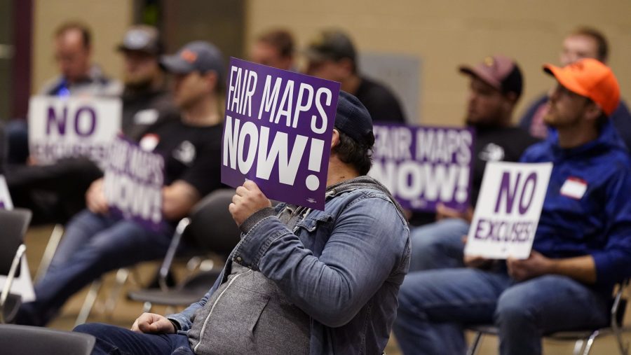 Protesters attend a meeting of Michigan's new Independent Citizens Redistricting Commission on Oct. 21, 2021, in Lansing, Mich.