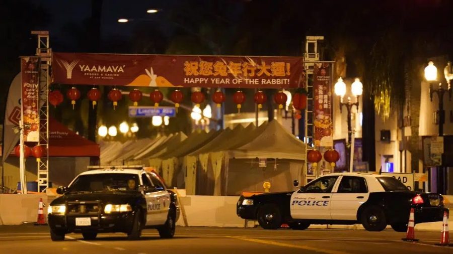 Two police vehicles are seen near a building where a shooting occurred in Monterey Park, Calif., Sunday, Jan. 22, 2023.