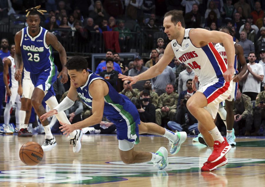 Dallas Mavericks guard Josh Green, front left, dives for the ball against Detroit Pistons forward Bojan Bogdanovic (44) in the second half of an NBA basketball game Monday, Jan. 30, 2023, in Dallas.