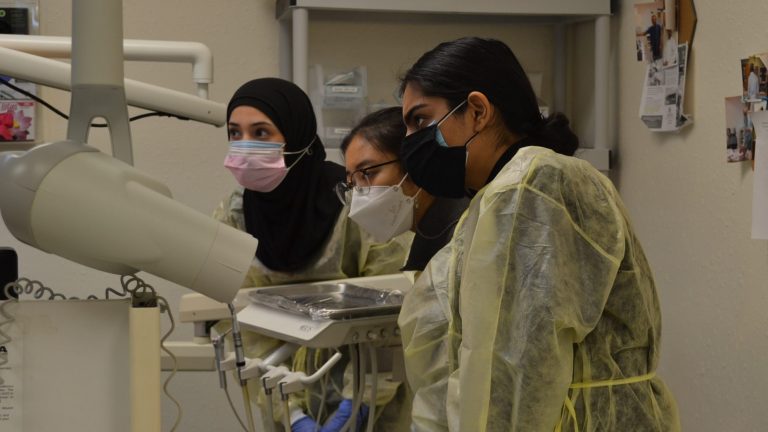 Dental students providing care for a patient at the HUDA Clinic.