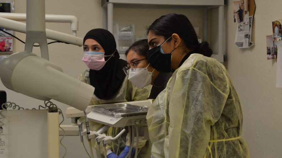 Dental students providing care for a patient at the HUDA Clinic.