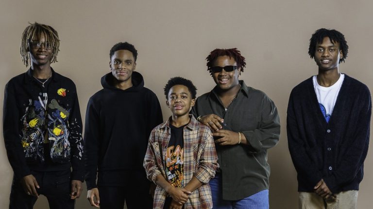five young Black men pose in a line