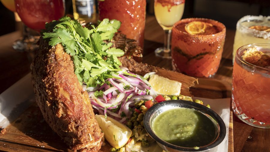 The Whole Fish of the Day dish at EM - Employee Meal sits on a table with a handful of specialized drinks inside the restaurant in Birmingham on Saturday, Feb. 11, 2023.