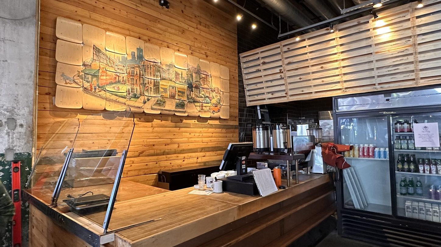 a wooden counter with a painted wooden mural depicting the Cass Corridor