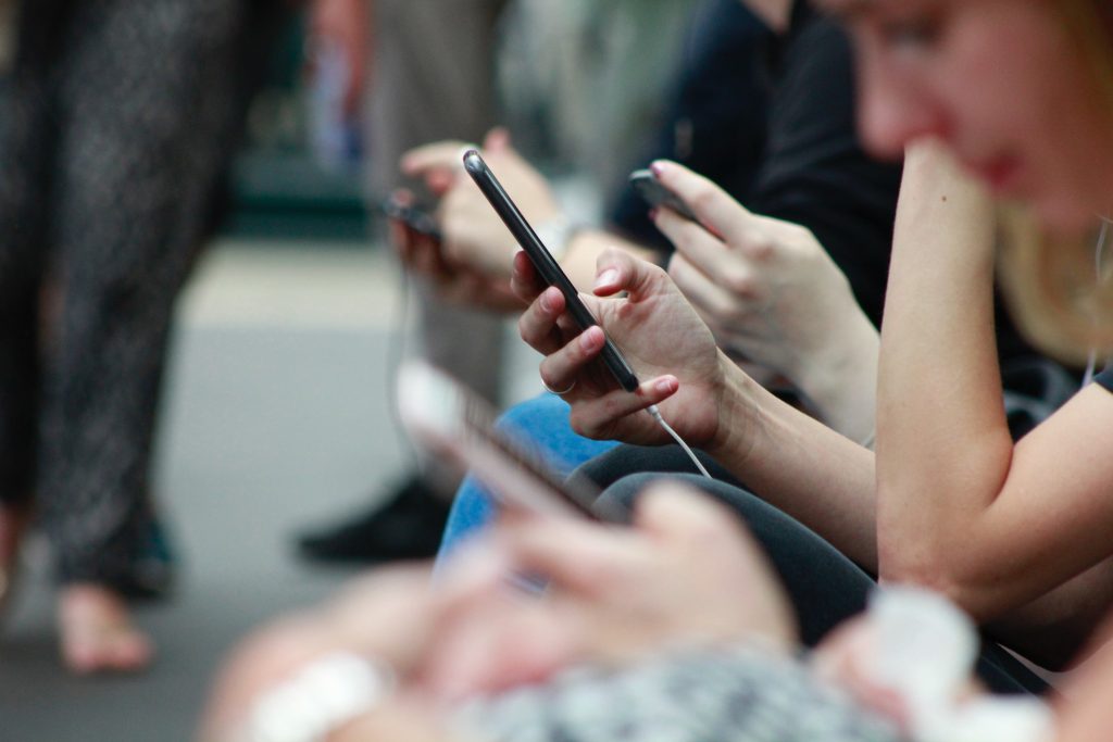 Stock photo of people looking at their smartphones.