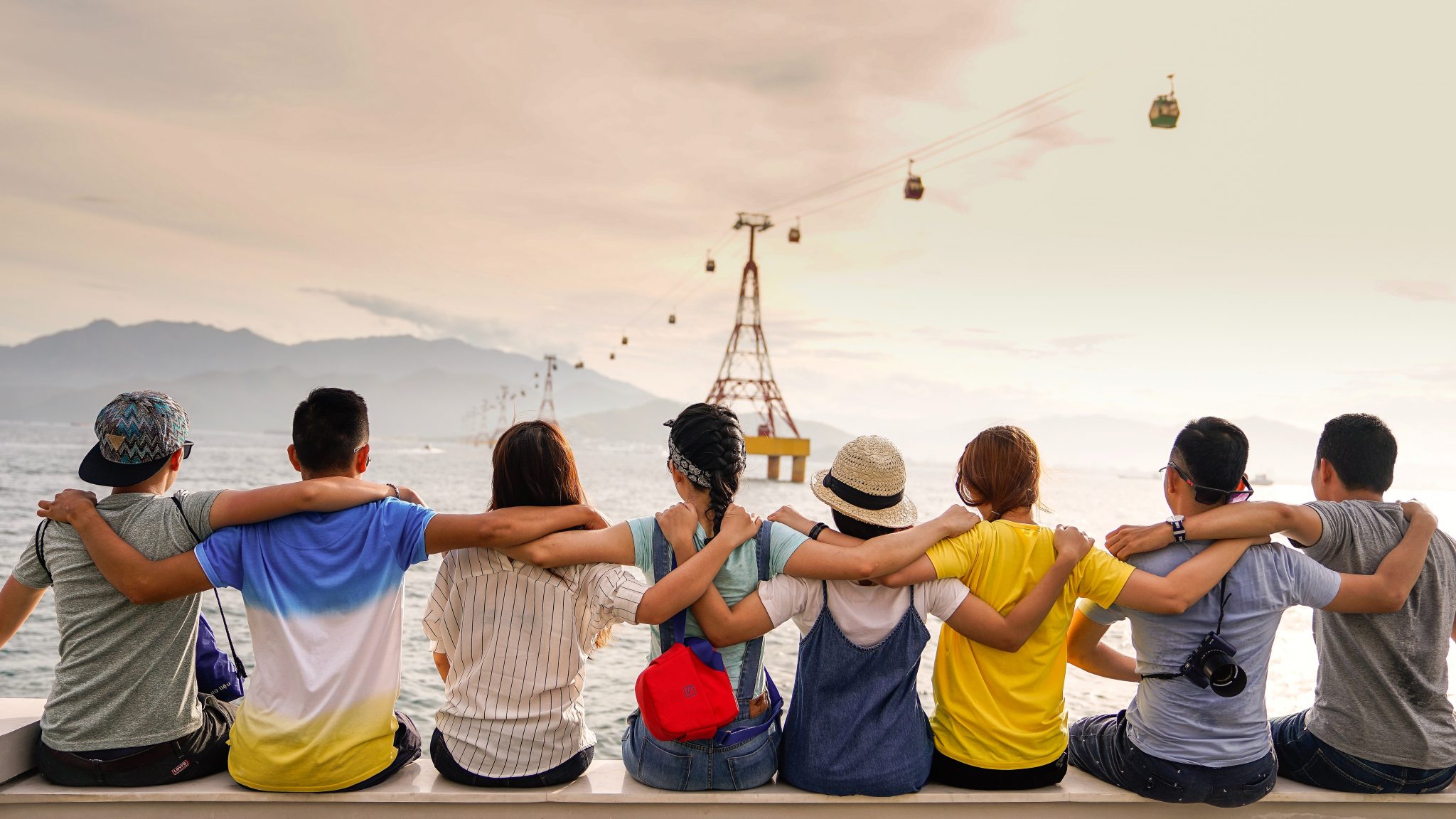 Stock photo of various people wrapping their arms around each other.