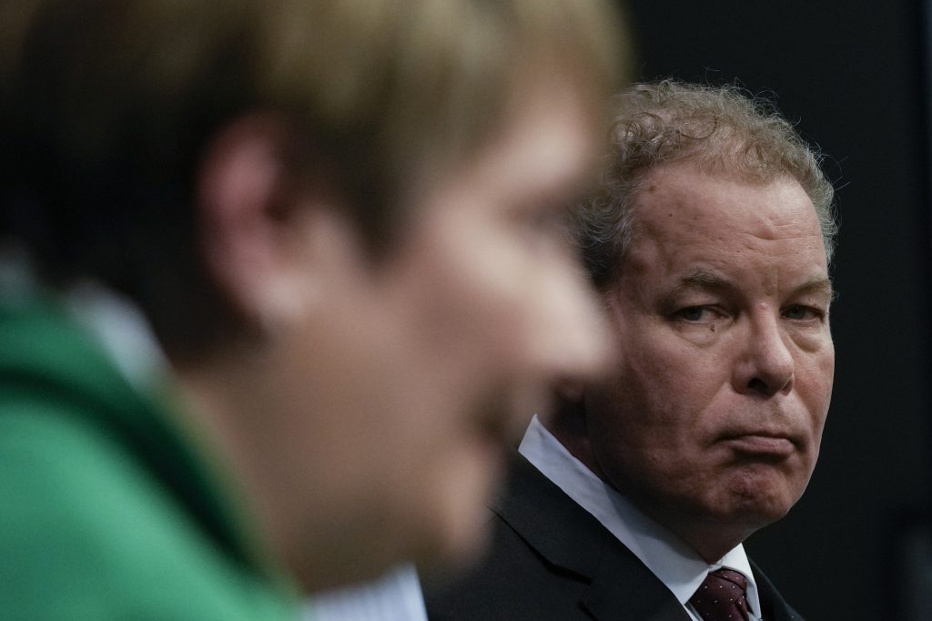 A man sternly looks over at a woman who is out of focus