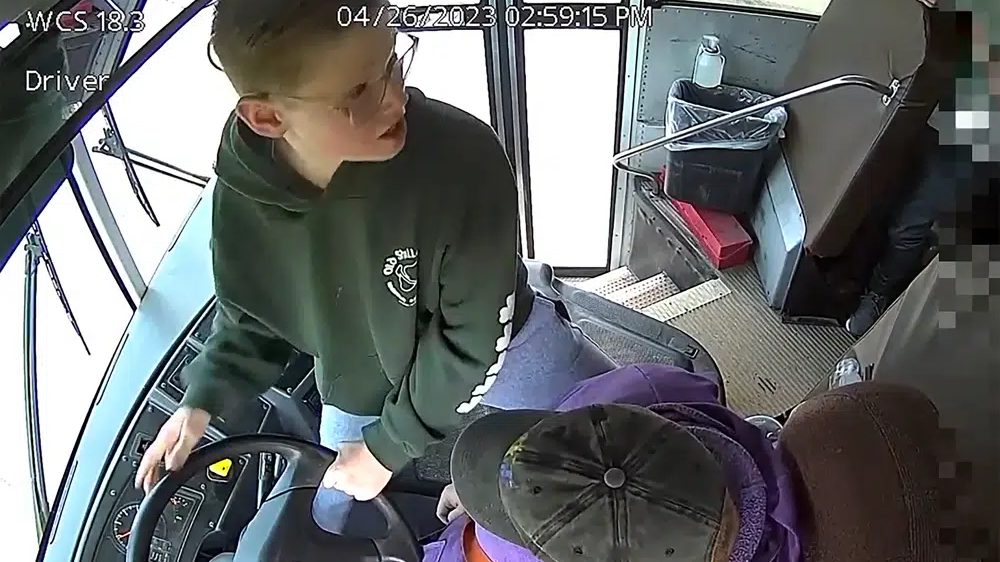 In this image made from video, seventh-grader Dillon Reeves grabs the steering wheel on his school bus and hit the brakes after the driver passed out Wednesday, April 28, 2023, Warren, Mi. Warren Consolidated Schools Superintendent Robert Livernois is calling it an “extraordinary act of courage.” (Warren Consolidated Schools via AP)