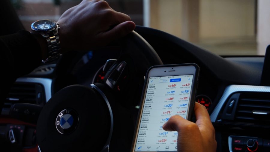 Photo of person using cell phone while driving.