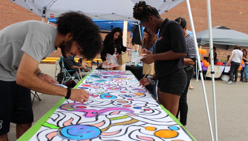 People collaborate on a colorful painting