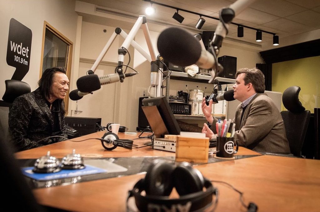 Sixto Rodriguez smiles while being interviewed by Craig Fahle in WDET's studios