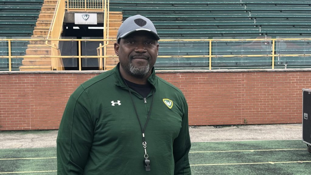 Coach Tyrone Wheatley smiles on Wayne State's football field