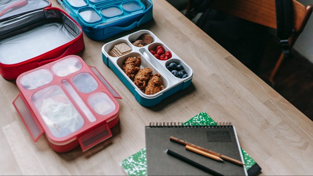 A photo of school lunch boxes on a desk.