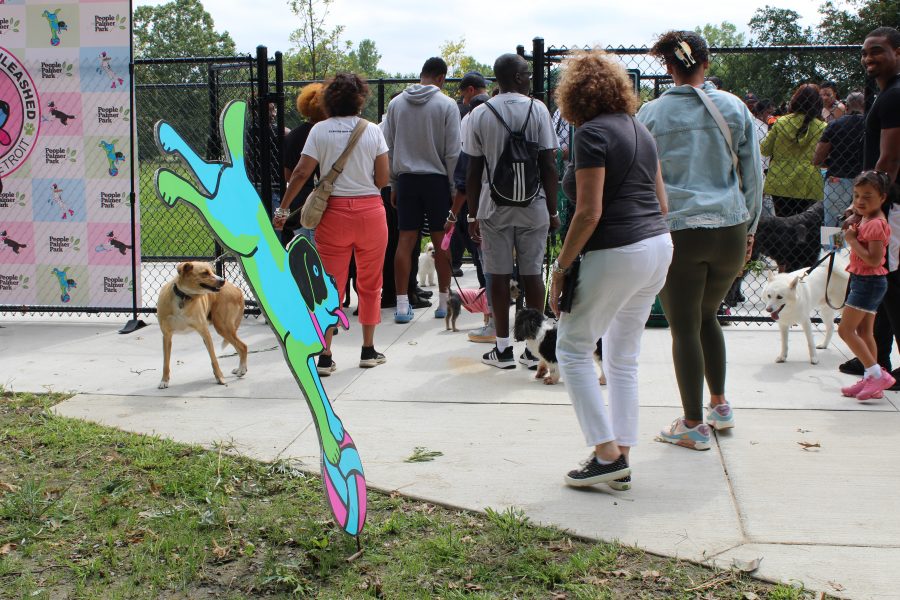 A crowd of people and their dogs squeeze into Palmer Park dog park during the grand opening.