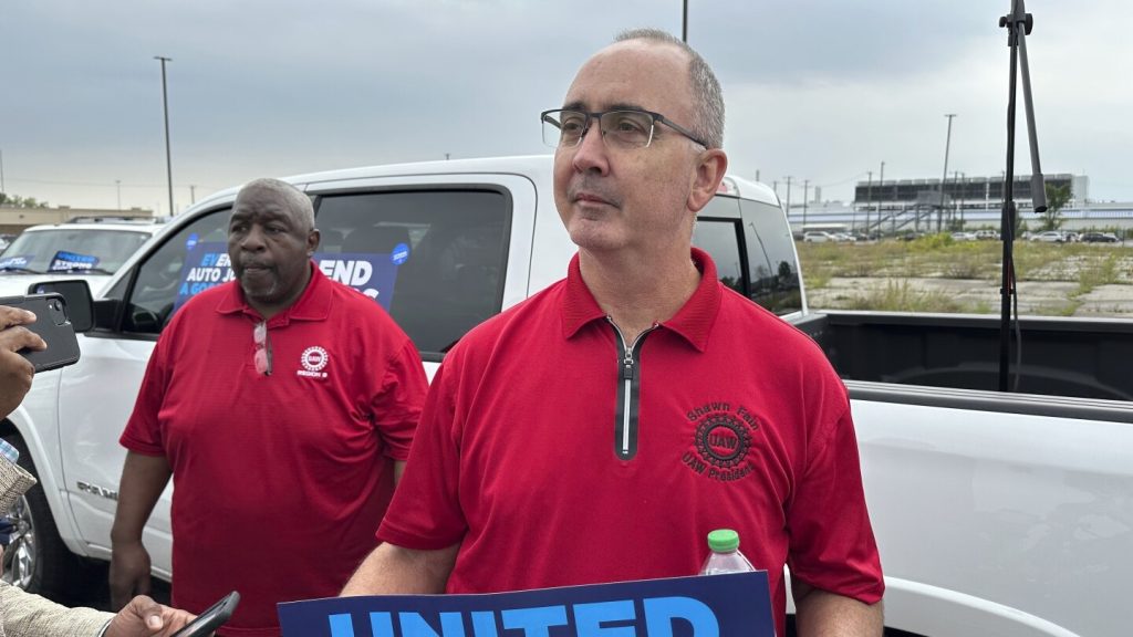 United Auto Workers President Shawn Fain holds up a sign at a union rally held near a Stellantis factory Wednesday, Aug. 23, 2023, in Detroit.