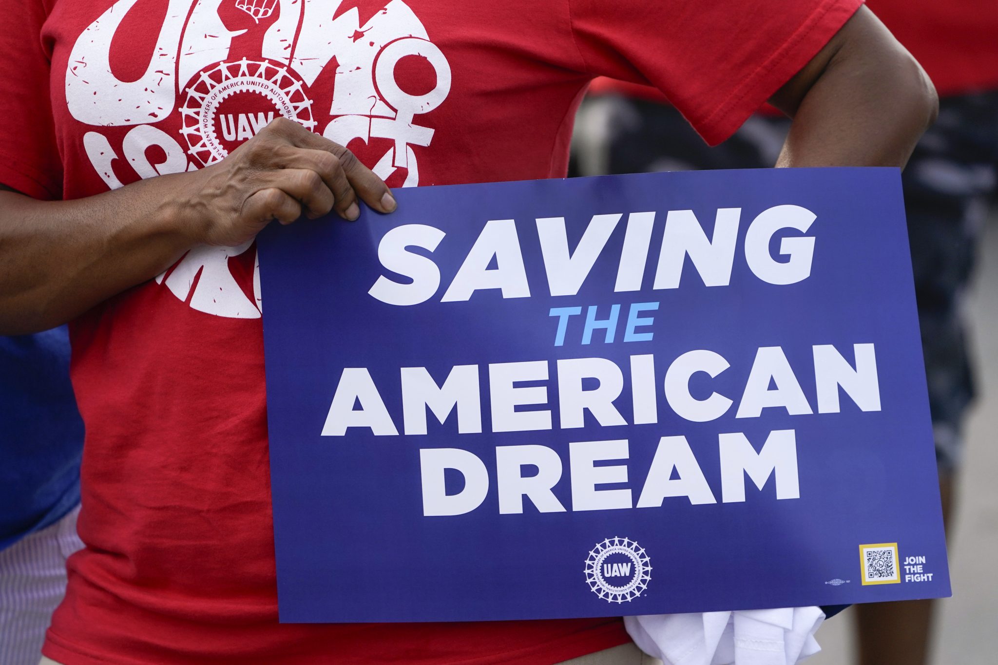 A United Auto Workers member holds a sign in the Labor Day parade in Detroit, Monday, Sept. 4, 2023. (AP Photo/Paul Sancya)