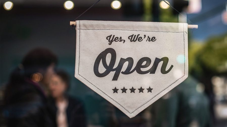 An open for business sign hanging on the door.