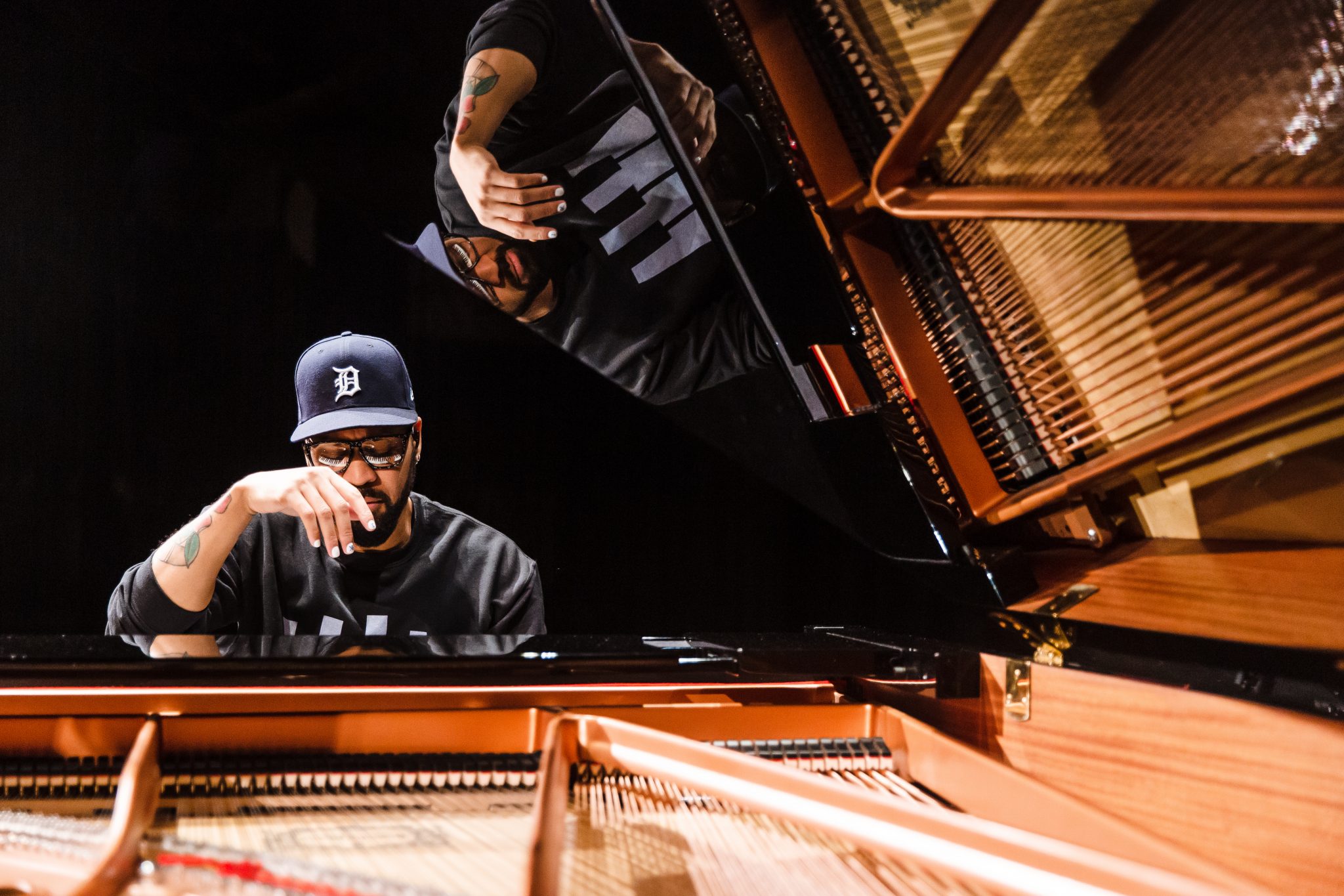 BLKBOK sitting at a piano.