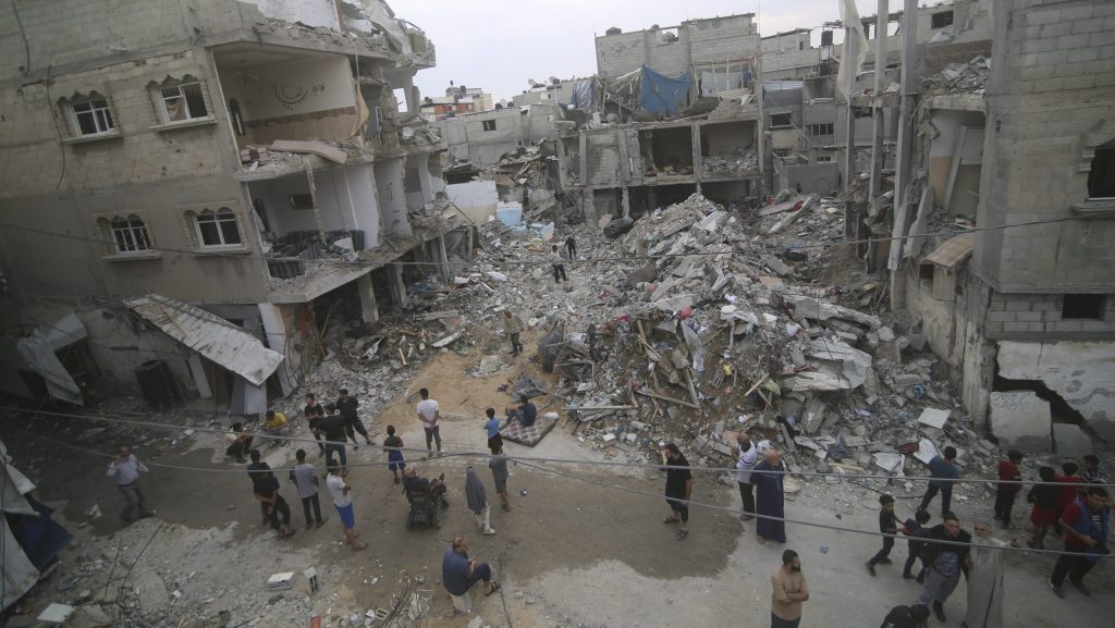 Palestinians inspect the rubble at a refugee camp in Rafah, Gaza Strip, after an Israeli air strike killed dozens of people, Monday, Oct. 9, 2023.