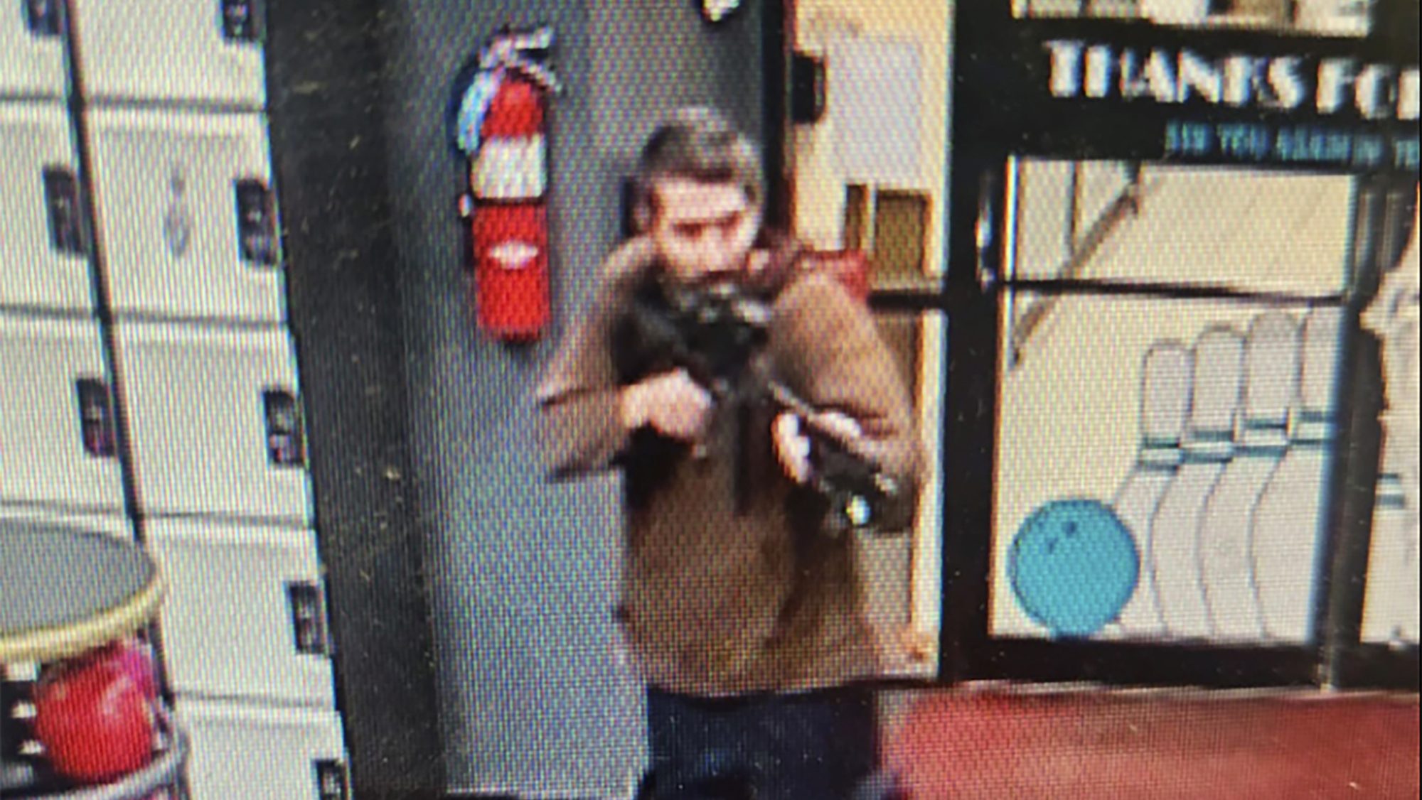 In this image taken from video released by the Androscoggin County Sheriff's Office, an unidentified gunman points a gun while entering Sparetime Recreation in Lewiston, Maine, on Wednesday, Oct. 25, 2023. Maine State Police ordered residents in the state's second-largest city to shelter in place Wednesday night as the suspect remains at large.