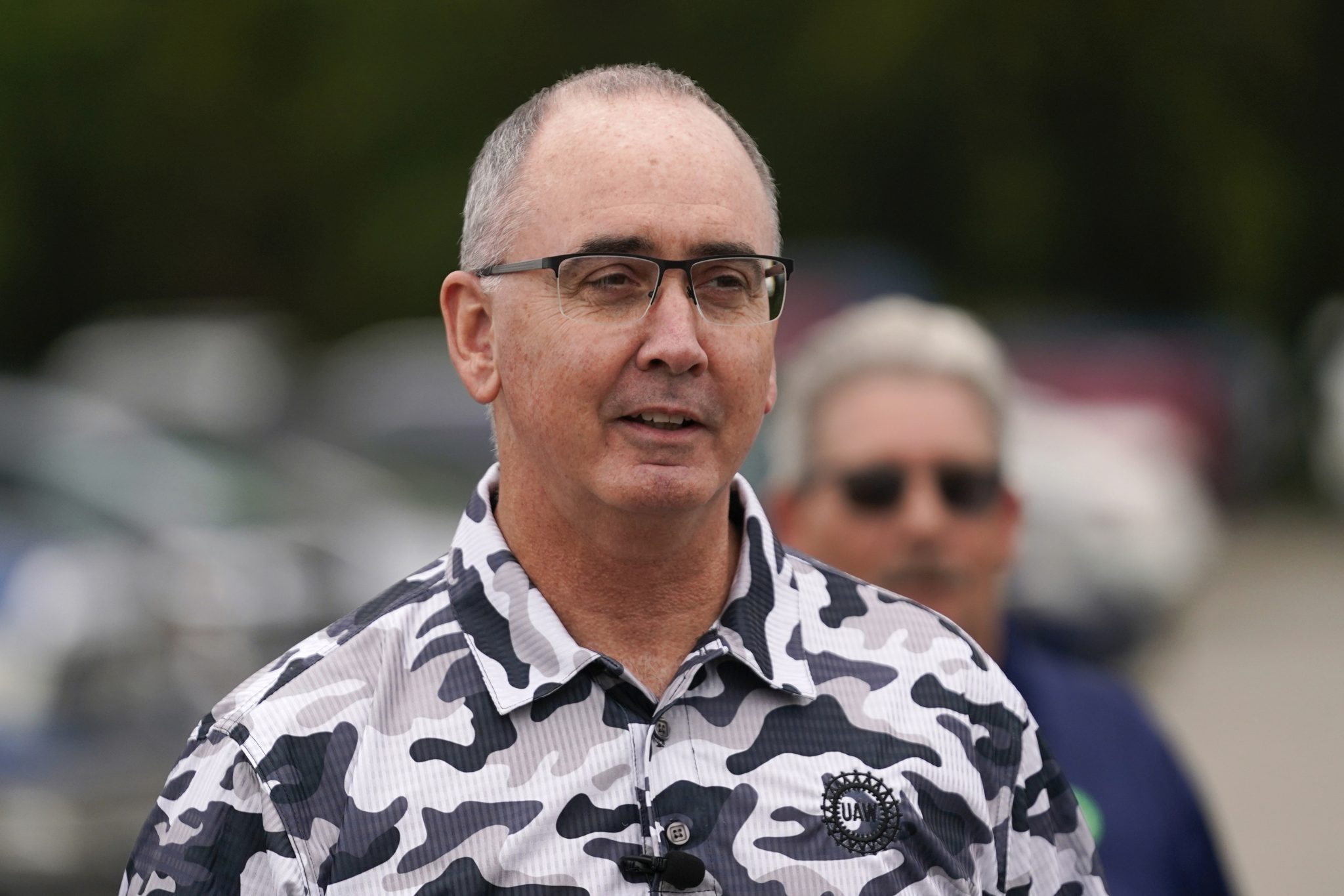 File - United Auto Workers President Shawn Fain talks with members picketing near a General Motors Assembly Plant in Delta Township, Mich., Friday, Sept. 29, 2023.