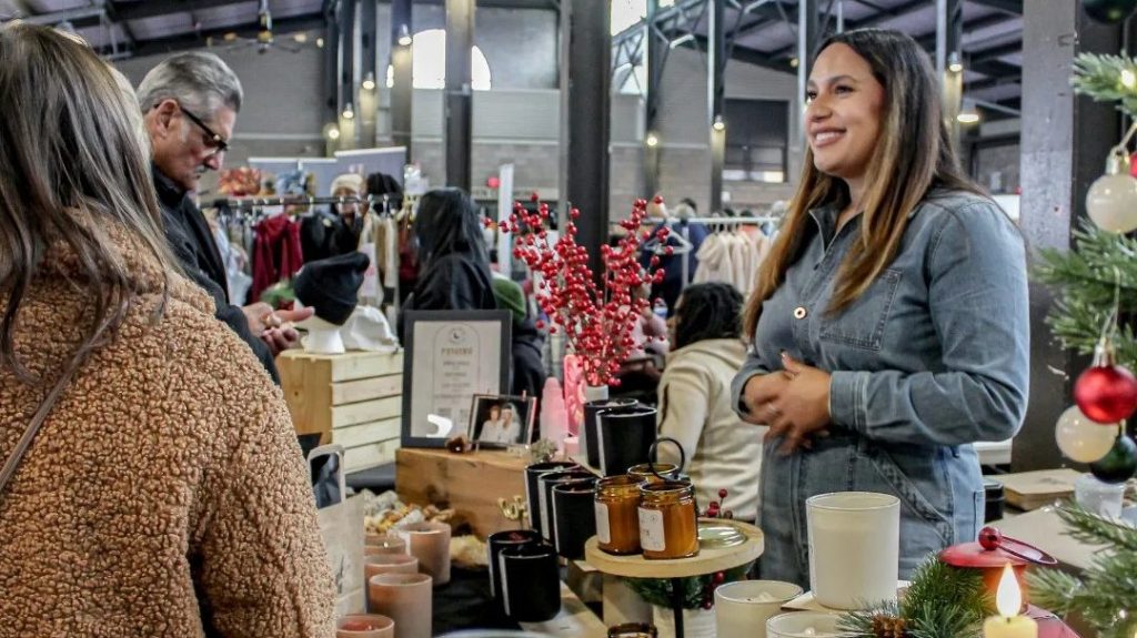 A local vendor sells candles in a crowded Eastern Market shed