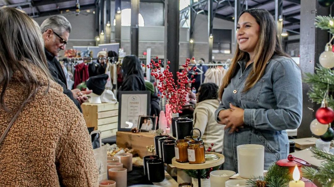 A local vendor sells candles in a crowded Eastern Market shed