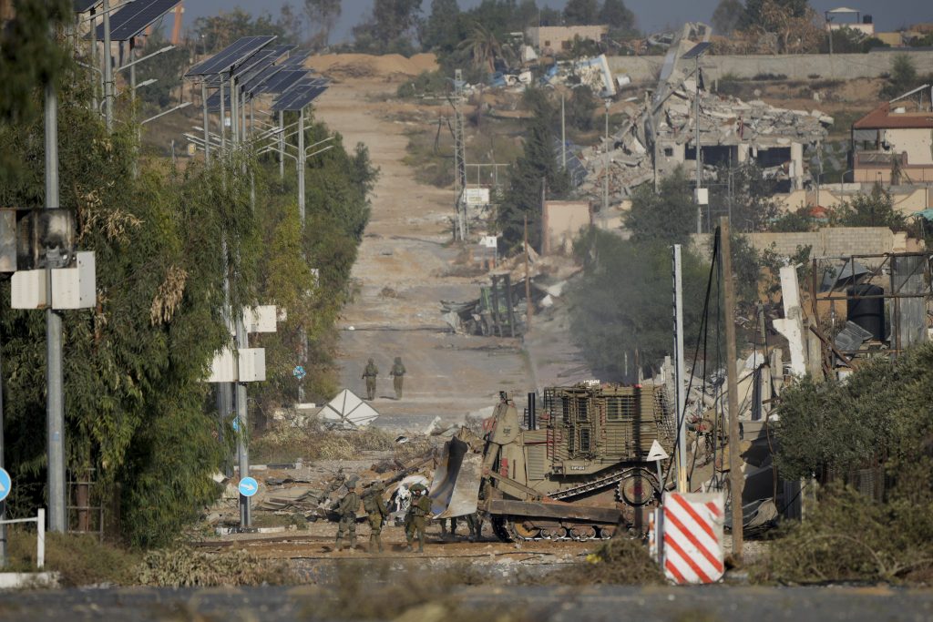 Israeli soldiers stand on Salah al-Din road in central Gaza Strip on Friday, Nov. 24, 2023, as the temporary ceasefire went into effect.