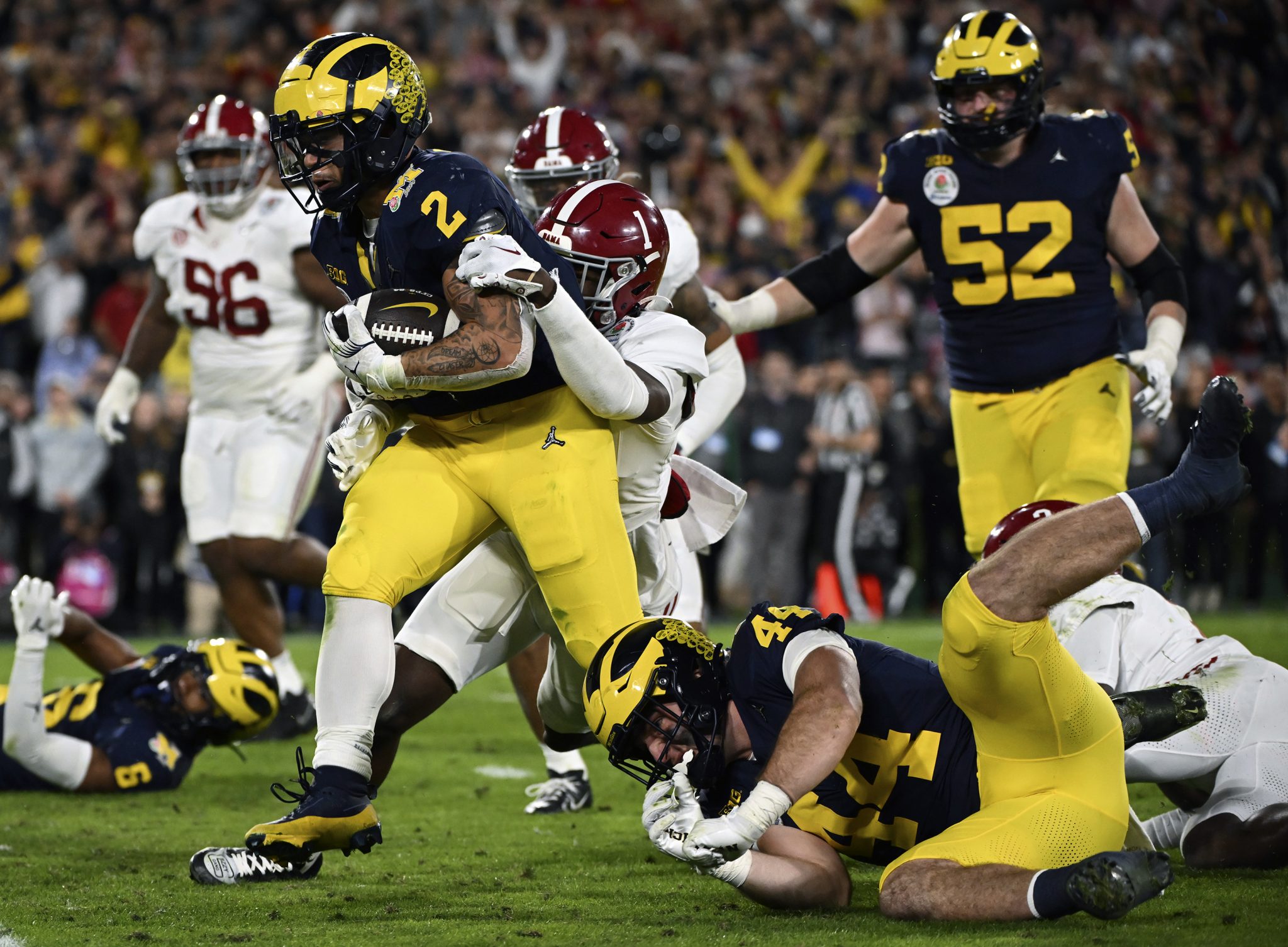 FILE - Michigan running back Blake Corum (2) runs in for a touchdown past Alabama defensive back Kool-Aid McKinstry (1) during overtime at the Rose Bowl CFP NCAA semifinal college football game Jan. 1, 2024, in Pasadena, Calif.