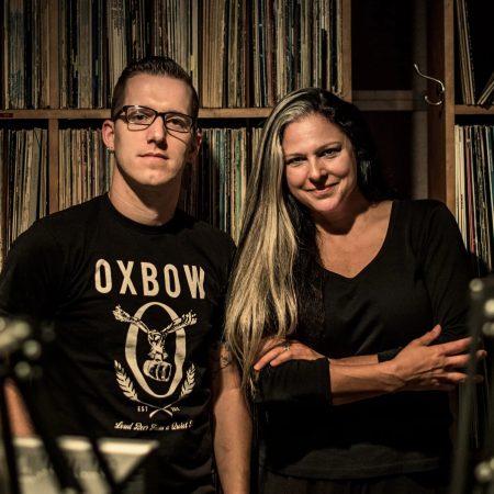 Chef James Rigato and Ann Delisi pose for a photo in front of records.