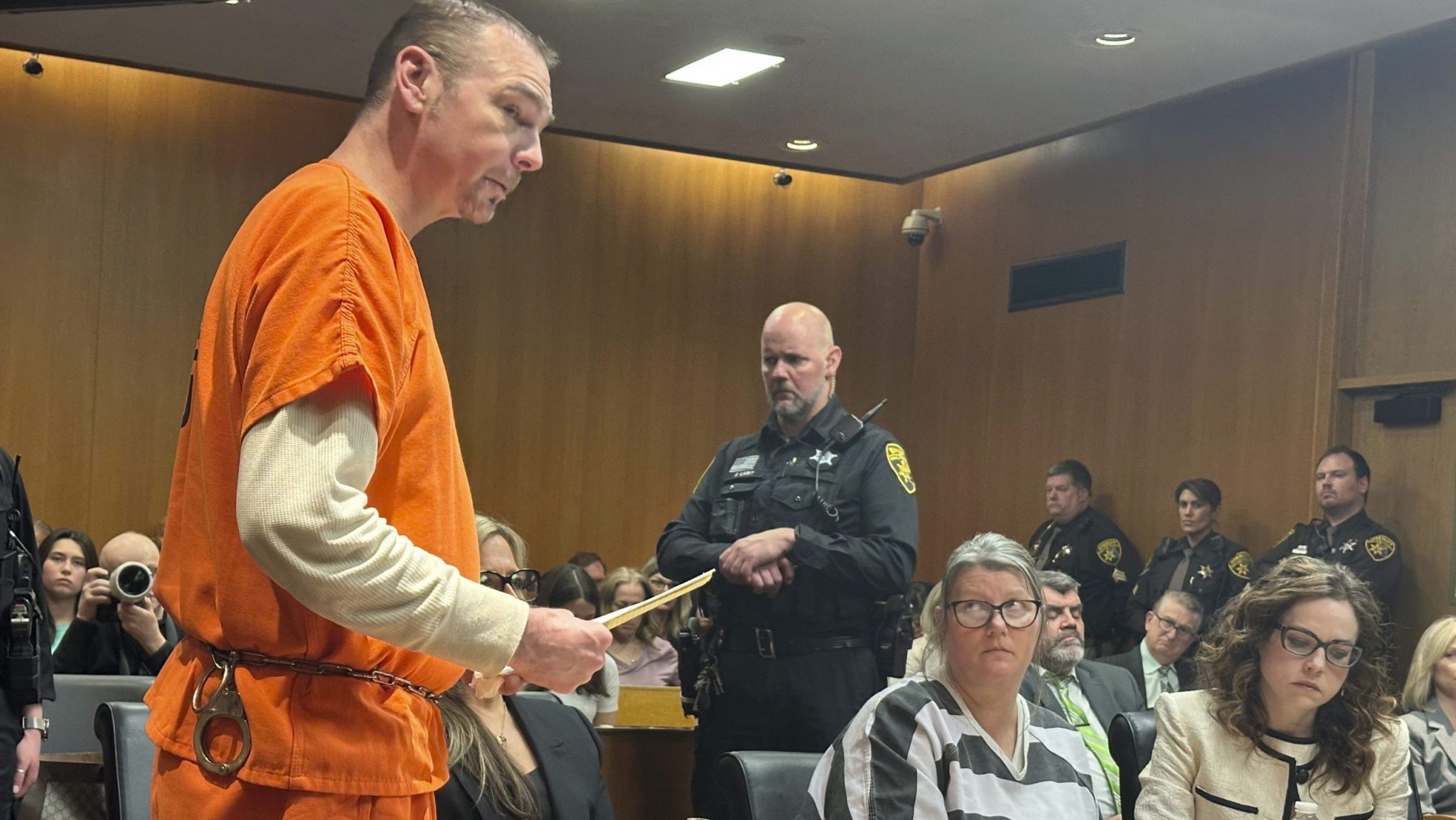 Defendant James Crumbley speaks before his sentencing for involuntary manslaughter in a school shooting committed by his son, Tuesday, April 9, 2024, in Pontiac, Mich. His wife, Jennifer Crumbley, center, listens. The Crumbleys were each sentenced to at least 10 years in prison Tuesday for failing to take steps that could have prevented the killing of four students in 2021.