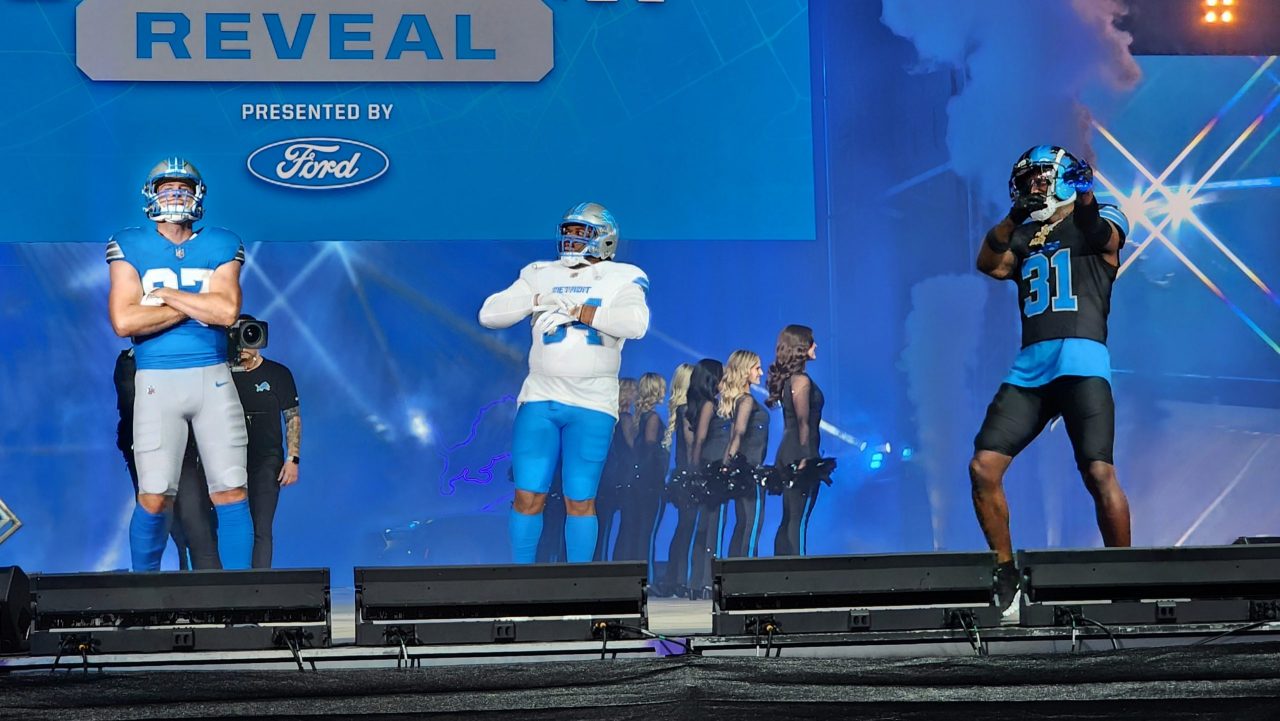 From left: Detroit Lions tight end Sam LaPorta, defensive tackle Alim McNeil and safety Kerby Joseph debut the Lions new uniforms during a season-ticket holder event at Ford Field in Detroit on April 18, 2024.