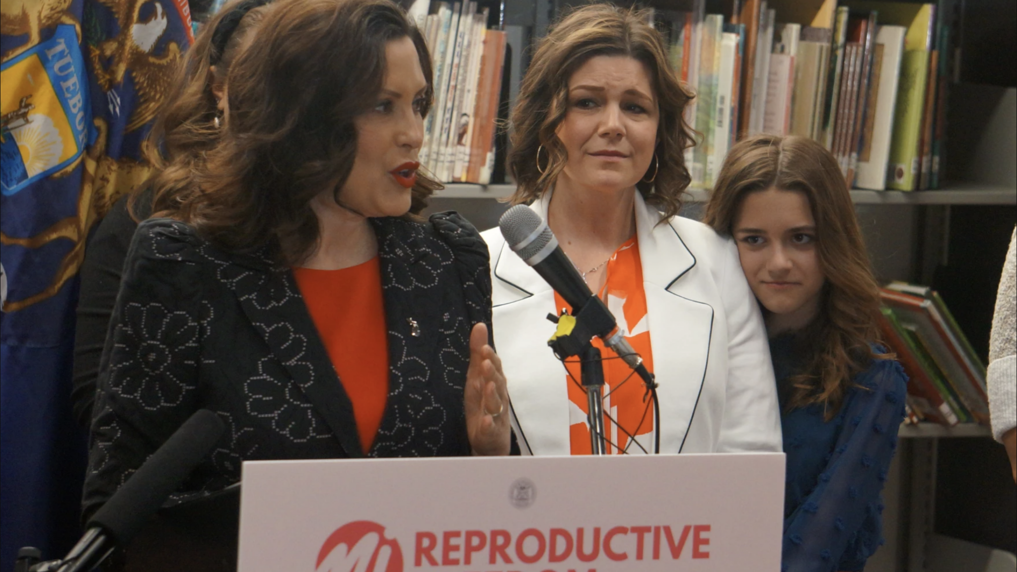 Tammy Meyers and 11-year-old Corryn watch Gov. Gretchen Whitmer at the ceremony to sign legislation to lift Michigan’s 35-year-old ban on paid surrogacy contracts.