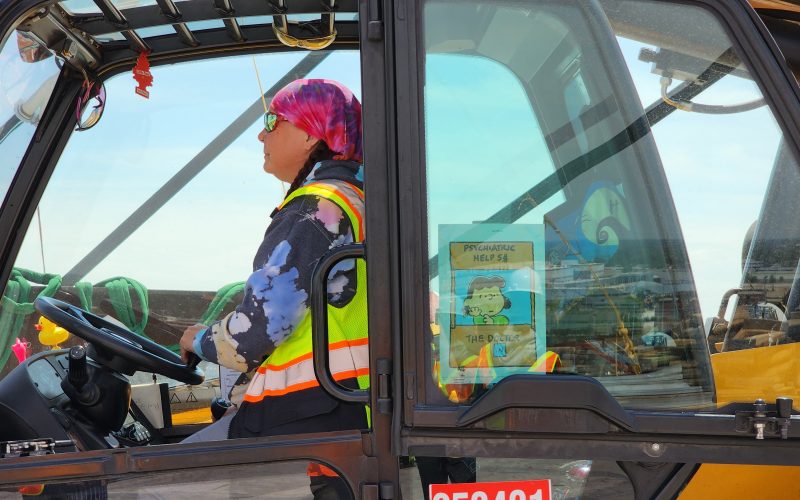 A machine operator sits in the cockpit on the Gordie Howe Bridge deck.