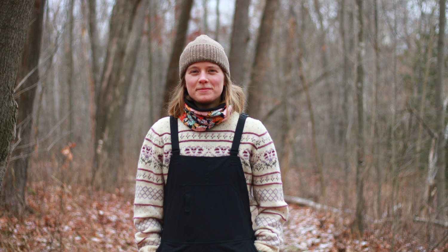 Eliza Thorp standing in a wooded area.