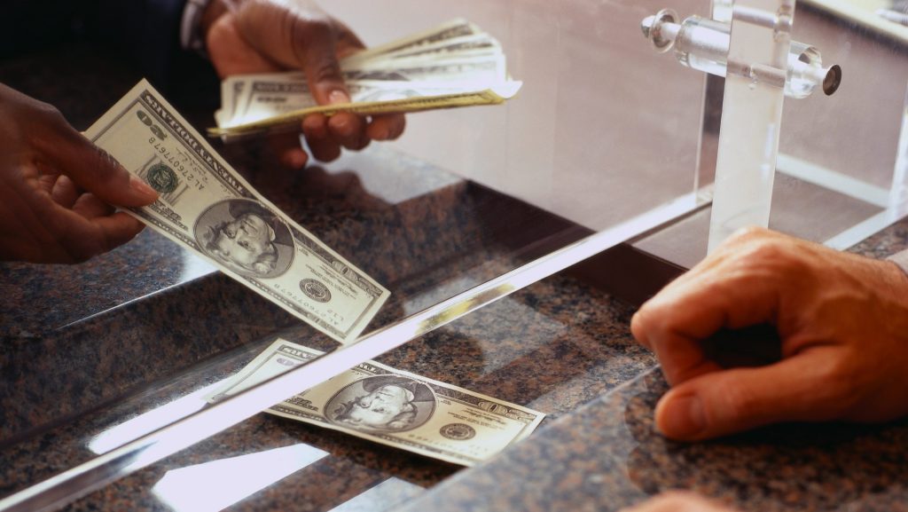 Bank Teller Counting Money for Customer