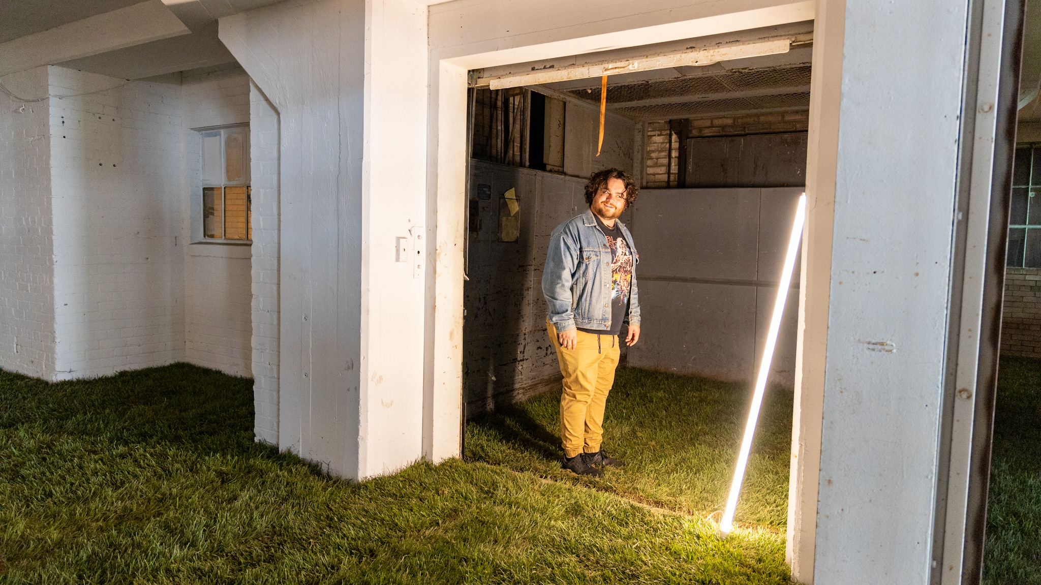 Ryan Patrick Hooper walks on the grass set inside the Boyer Campbell Building in Detroit for the Petrichor botanical art installation on May 30, 2024. (Photo credit: Tayler Simpson, WDET)