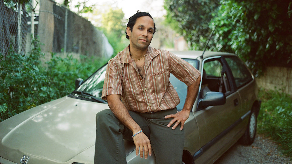 Pachyman sitting on the hood of a car.