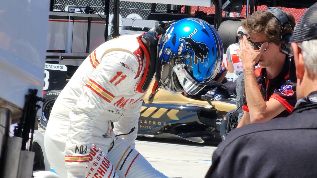 Nolan Allaer, 22, of Grosse Pointe Woods, wears a Detroit Lions-themed race helmet as he climbs into his car at the Detroit Grand Prix.